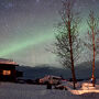 ロッジの上にオーロラが広がるコジーなロッジ