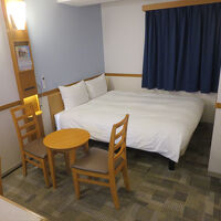 客室はかなり広くクィーンサイズベッドにテーブルがあります。