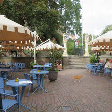 …人工の丘の麓のカフェの屋外席を通り過ぎた所に…、