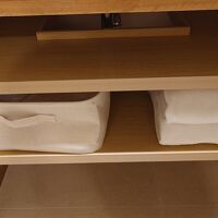 洗面台の下にワンピース型ルームウェアとタオルあり