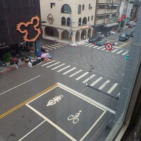 窓からすぐ前の道路を見下ろす。右奥が六合夜市