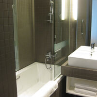 清潔なバスルーム。茶色のタイル張りがシック。