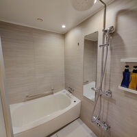 大型のバスタブとレインシャワーのあるバスルーム