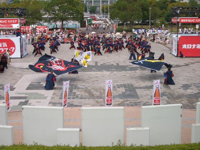 名古屋市で第七回「にっぽんど真ん中祭り」があり、名古屋港会場「オロナミンCスクエア」の祭りに参加してきました。<br />通称「ど祭り」は名古屋市内１１箇所で２６日（前夜祭）〜２７日（本祭り）開催。踊り手が日本はもとより、外国からの参加もあり（１７５チーム、２万人が参加）観客動員１０４万人と規模の大きい夏の祭りです。私はこの「ど祭り」が毎年楽しみで参加していますが、この祭りが来ると一番夏を感じます。<br />会場では３時間ほどいましたが、肌の出ているところは真っ黒に日焼けしてしまいます。<br />踊り手と観客がいったいとなった、すごく楽しい祭りでした。<br />踊っているチームは「夜宵」