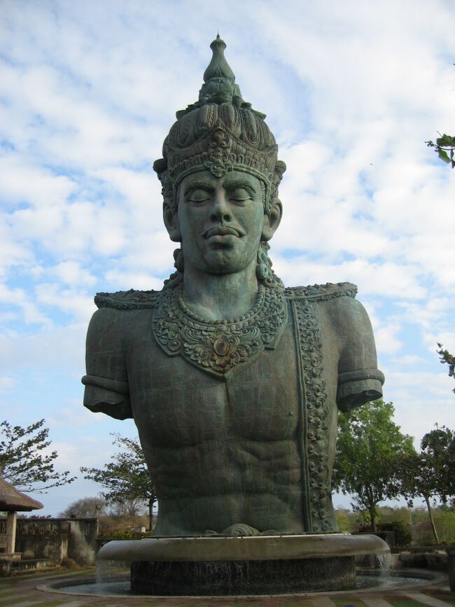 ジンバランにある『GWK（ゲーウェーカー）』です。<br />正式名称は「The Mandara Garuda Wisnu Kencana Cultural Park」で、その頭文字を取って「GWK」と呼ばれています。<br /><br />比較的新しいと言える観光名所がジンバランにある「GWK ゲーウェーカー・カルチュラルパーク」。（このGWKをゲーウェーカーと読むのはインドネシア語の発音）<br />20ヘクタールにも及ぶ広大な公園のてっぺんには、超巨大なガルーダ・ウィシュヌ像がそびえています。<br />（フリー百科事典『ウィキペディア（Wikipedia）』より引用）<br /><br />夕陽の名所・ジンバランからほど近い丘に建つ、高さ約120メートルの銅像。その名も「ガルーダ・ウィスヌ・クンチャナ像」が、2018年夏に完成しました。「バリ島に新しいシンボルを」と28年にわたって進められてきた建設計画が、ついに実を結んだのです。<br /><br />バリの伝統文化を体験できるカルチャーパークへGO!  <br />像が建てられている場所は、2000年にオープンした「GWK カルチュラルパーク 」。ケチャやバロンダンスなどの舞踊ショーを鑑賞できる屋外シアターや、バリ雑貨を扱うお土産ショップ、インドネシア料理のレストランやカフェなどが並び、バリの伝統文化を丸ごと堪能できるカルチャーパークです。<br />約250ヘクタールもの広大な敷地は緑豊かで、インドネシア国内からの観光客でにぎわっています。一方で海外からの観光客はまだまばらで、穴場感が楽しめます。<br /> <br />まず視界に飛び込んでくるのが、「ウィスヌ像」。水を司るヒンドゥー教の神様・ウィスヌ神の上半身像で、高さ約20mとかなりの迫力です。<br />像のすぐ隣には、聖水が湧き出るパワースポット「スマカ・ギリ寺院」があります。<br />「ウィスヌ像」の奥に、巨大なガルーダの頭部が！ ガルーダとは、神話にたびたび登場する黄金の神鳥で、ウィスヌ神の乗り物としても知られています。インドネシアの国章でもあり、ガルーダ・インドネシア航空の名称はここから名付けられています。<br /> <br />コンサートなどのイベントが行われる「Plaza Garuda（ガルーダ広場）」を通り抜け、「ガルーダ・ウィスヌ・クンチャナ像」へと続く道を進みます。道の両脇にそびえ立つのは削られた石切り場。ちょっとしたアドベンチャー気分が味わえ、隙間から見え隠れする姿に期待が高まります。<br /> 近づくと、ビルの上に建つできたてピカピカの「ガルーダ・ウィスヌ・クンチャナ像」が！ ウィシュヌ神が、翼を広げた神鳥ガルーダに乗る姿が表現されています。 <br />像を見るだけなら、１時間程度でOK。ケチャダンスで有名なウルワツ寺院からも近いので、気軽に立ち寄ってみてはいかがでしょうか。<br />https://www.travel.co.jp/guide/article/35758/　より引用<br />