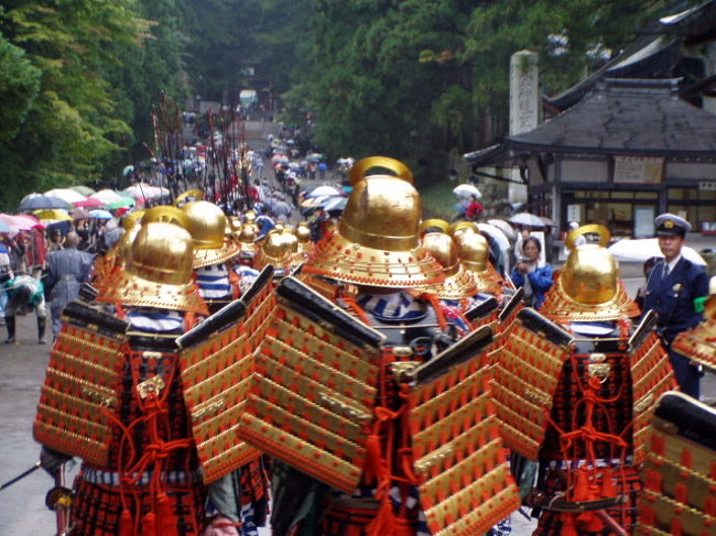 世界遺産の日光・東照宮に数ある年間行事の中でも、最も盛大な神事が 二荒山神社より出発する東照宮神輿・百物揃千人武者行列（ひゃくものぞろいせんにんむしゃぎょうれつ)です。この徳川家康公の神霊を駿府久能山から日光へ改葬した当時の行列を再現した「千人武者行列（神輿渡御祭・しんよとぎょさい）」は実物を見てしまうと正に圧巻の歴史絵巻ですよ。<br /><br />午前１１時に神輿舎前を出発した千人武者行列は、表参道から御旅所までの約１ｋｍを、鎧武者・鎗持ち姿などで練り歩き、最後尾に神君・家康公の神輿が続きます。<br />行列が御旅所に着くと「御旅所祭」が行われます。神輿は御旅所神殿に祀られ、拝殿には三品立(さんぼんだて)七十五膳と呼ばれる山海の幸が神職の手で供えられて、日光二荒山神社の巫女による「八乙女の舞」、日光東照宮神職による「東遊びの舞」の二つの舞が古式雅やかに奉納され、内外の呪いを取りさらいます。当初の予定は１３時頃でしたが、小雨混じりのこの日は、１時間ほど早目の進行で東照宮の境内に向けて行列は還っていきました。神興は日光東照宮に向かい神興舎に安置され、還御祭が行われ御霊は御本社に遷霊することに。<br /><br />◆御迎榊 10:30 渡御する参道〈中山通り⇒表参道（大手通り）⇒上新道⇒二荒山神社〉を榊にてきよめる<br />◆10:35 二荒山神社御本殿より神輿に遷霊<br />◆渡御 11:00 二荒山神社前進発〈上新道⇒五重塔前⇒表参道(大手通り・中山通り）⇒御旅所〉<br />◆御旅所祭 12:00 ３基の神輿は、御旅所にある御神殿に祀られその前にある拝殿にて、東照宮宮司以下神職らで祭典が執行される（三本立七五膳、八乙女の舞、東遊の舞）<br />◆12:40　還御 13:00 御旅所進発〈表参道(中山通り・大手通り）⇒五重塔前⇒陽明門⇒東照宮神輿舎〉<br />◆還御祭 13:30 神輿舎前にて神輿より御本社に遷霊され、宮司以下神職により祭典が執行され例大祭が終了。<br /><br />しかし、凄いことにこの行列で使われる装束は修繕はされていますが、３００年前と同じ物だそうですよ！<br /><br />しかも江戸時代の昔から、現在まで代わることなく、千人武者行列の奉仕は市内の各自治会に割り当てられ、そのほとんどが日光市民によって成り立っています。<br /><br />今回の写真はどちらも２００５年、晴れた今年の春の例大祭と、小雨の秋の１０月１７日のものからピックアップしてみました。。。<br /><br /><br />おまけ（千人行列の内訳）・・・この順番で歩きます。<br /><br />1.兵士鉾持ひょうじほこもち　　100人警固２人<br /><br />2.職士鉾持　　神人１人<br /><br />3.獅子　　神人３人<br /><br />4.獅子　　神人３人<br /><br />5.笛　　神人１人<br /><br />6.田楽法師　　宮士１人<br /><br />7.大拍士　　神人１人<br /><br />8.八乙女<br /><br />9.祢宜　　騎馬　　素袍１人・白張４人<br /><br />10.権宮司　　騎馬　　 素袍１人・白張４人<br /><br />11.御神馬　　3疋　白張６人<br /><br />12.御鉄砲持　　５０人警固２人<br /><br />13.御弓持　　５０人警固２人<br /><br />14.御鎗持　　５０人警固２人<br /><br />15.鎧武者　　１００人警固２人<br /><br />16.稚児　１２人警固２人<br /><br />17.掛面　　５０人警固２人<br /><br />18.御翳おさしば　　神人４人<br /><br />19.御太刀禰宜　　騎馬　御太刀付神人１人　素袍１人白張４人<br /><br />20.御旗禰宜　　騎馬　御旗付 神人１人　素袍１人白張４人<br /><br />21.斎鉾いみほこ三本　　白張15人警固6人<br /><br />22.祭旗八本　　白張40人警固16人<br /><br />23.葵太鼓　　白張4人<br /><br />24.鉦鼓　　白張2人<br /><br />25.猿牽　10人<br /><br />26.宮仕　　6人<br /><br />27.神人　　50人<br /><br />28.伶人　9人<br /><br />29.荷太鼓・荷鉦鼓　白張3人　白張2人<br /><br />30.鷹匠　　10人<br /><br />31.御枕木・御枕木　白張2人　白張2人<br /><br />32.御幣　神人1人<br /><br />33.禰宜　騎馬　素袍1人白張4人<br /><br />34.禰宜　騎馬　素袍1人白張4人<br /><br />35.素袍着　　15人<br /><br />36.御本社神輿　　白張50人警固40人<br /><br />37.子供猿　　８人<br /><br />38.旧同心<br /><br />39.巴太鼓　　白張３人<br /><br />40.鉦鼓　　白張１人<br /><br />41.御枕木・御枕木　白張２人・白張２人<br /><br />42.御幣　　神人１人<br /><br />43.素袍着 15人<br /><br />44.御左神輿　　白張50人警固40人・今市世話人<br /><br />45.子供猿　　８人<br /><br />46.旧同心　　白張３人<br /><br />47.茗荷太鼓　白張３人<br /><br />48.鉦鼓　　白張１人<br /><br />49.御枕木・御枕木　　白張２人・白張２人<br /><br />50.御幣　　神人１人<br /><br />51.素袍着　　１０人<br /><br />52.御右神輿　白張５０人警固４０人<br /><br />53.子供猿　　８人<br /><br />54.旧同心<br /><br />55.宮司　　騎馬　直垂２人素袍１人白張４人<br /><br />56.禰宜　　騎馬　素袍１人白張４人<br /><br />57.禰宜　　騎馬　素袍１人白張４人<br /><br />58.里山伏　　若干<br />　　副会長　　騎馬　白張１人<br />　　産子総代　　騎馬　白張１人<br />　　後衛副会長　騎馬<br /><br />（「御祭礼方式ならびに取り扱い方一件」『社家御番所日記』一五所収）。<br />これは、嘉永六年（1853）頃のものと思われますが、今も変わることなく、こうして続いているんです。 <br /><br />注】行列に関する詳しい解説は参考にさせていただいた「日光を漂う」をご覧ください。<br />http://dendo-annai.blog.ocn.ne.jp/nikko/