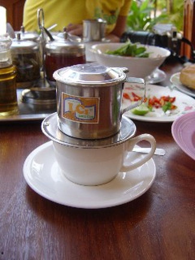 思い出のサイフォンコーヒー<br /><br />ベトナムを初めて訪れたとき、わたしが街の至る所にカフェがあることに驚かされます。カフェで小さなアルミフィルターで一杯ずつドリップするのを待ちながら、時間を過ごし、そんなのんびりとしたスタイルにも驚かされます。<br />実はベトナムはブラジル以外に次ぐ世界第2位のコーヒー生産国なのですって!!ベトナムコーヒーはフランス統治時代から培われた歴史がありますが、味も形もフランスと違います。<br />玩具みたいなアルミフィルターはホントに安っぽいアルミ素材で強く押さえるとすぐ曲がってしまいそうだけど、ペーパードリッパーを無駄使いすることもないので、やはり手軽に入れられるんですね。私も、贈り物として4セットを買いました。<br /><br />サイフォンコーヒーの方が好きなわたしが、今度のベトナムの旅に、私の口に合うコーヒーに出会えないはずかも知れないと思っていたけど、今ベトナムコーヒーの濃さも甘さも風味も飲んで、とても新鮮感があります。ミルクコーヒーにはコンデンスミルクが使われ、その甘みによって豊潤な味わいが引き立てられることを覚えます。なお、ベトナムのコーヒー豆は、苦みのボディが強く、深く焙煎するので香ばしいロースト香を持っています。アルミフィルターでゆっくりとドリップすると、香り豊かで、濃厚で、甘みさえも感じます。<br /><br />ベトナム式コーヒーの入れ方:<br /><br />まず、コップの底にコンデンスミルクを敷きます。<br />コーヒーフィルターのふたを開けます。<br />中にあるコーヒー押さえを取り外します。<br />コーヒーフィルターの中にコーヒーの粉を入れます。<br />取り外したコーヒー押さえを上からかぶせます。<br />コーヒーフィルターをコップの上にセットします。<br />上からお湯を注ぎ込みます。<br />上フタをして、少し待ちます。<br />コーヒーとコンデンスミルクをスプーンで混ぜてください。<br />ベトナムコーヒーの出来上がりです。<br /><br />コンデンスミルクをたっぷり入れたベトナム式コーヒーをぜひお楽しみください。<br /><br />の入れ方:<br /><br />まず、コップの底にコンデンスミルクを敷きます。<br />コーヒーフィルターのふたを開けます。<br />中にあるコーヒー押さえを取り外します。<br />コーヒーフィルターの中にコーヒーの粉を入れます。<br />取り外したコーヒー押さえを上からかぶせます。<br />コーヒーフィルターをコップの上にセットします。<br />上からお湯を注ぎ込みます。<br />上フタをして、少し待ちます。<br />コーヒーとコンデンスミルクをスプーンで混ぜてください。<br />ベトナムコーヒーの出来上がりです。<br /><br />コンデンスミルクをたっぷり入れたベトナム式コーヒーをぜひお楽しみください。<br /><br /><br />