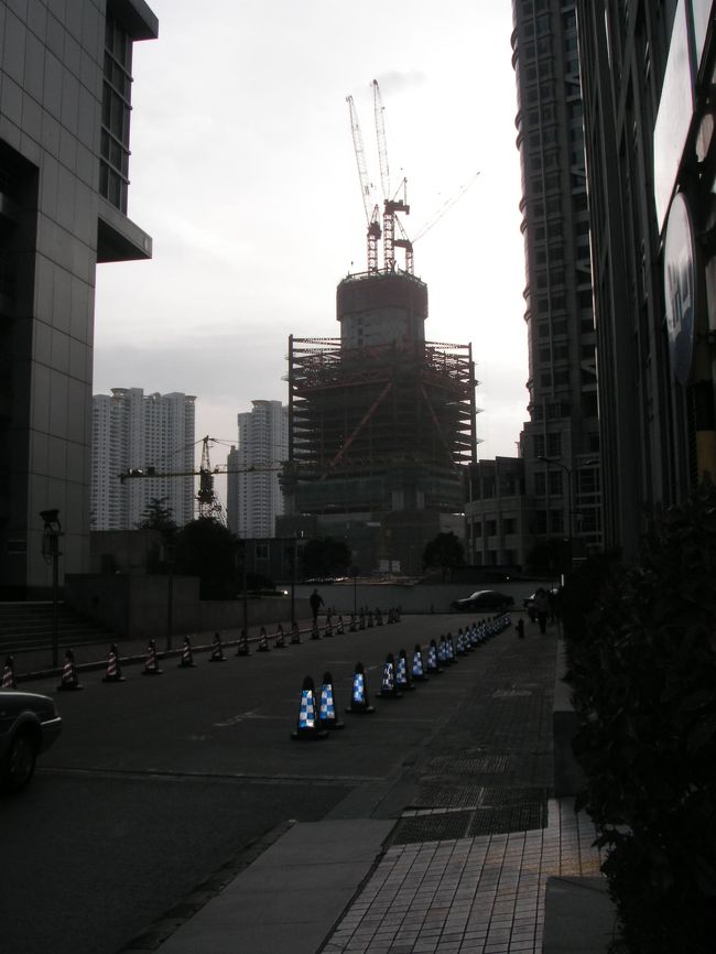 <br />　出不精で今日２月２３日は１２月２９日以来出かけてみました。<br />　上海のマハッタンと謂われる「陸家嘴」の森ビル界隈です。<br />　工事中の「国際ファイナンシャルビル」此処まで延びていました。<br /><br />　「上海証券ビル」の空き地から覗けます。<br />　この「証券ビル」の裏側にも新しいビルが建つので工事中の為偶然顕われたのです。<br />　普段は絶対に見れない位置です。<br /><br />　以下、何れも夕刻５時頃の撮影なので背景が暗いです。