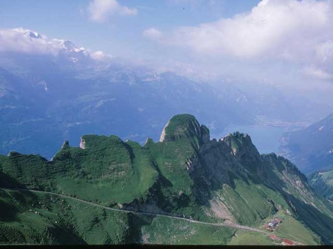 この４トラ旅行記は最近の年の方から順にアップしてきたが今回は2002年の旅のうちスイスの旅をアップします。４年も前のなので記憶間違いが出てくるのではと危惧しています、もしお気づきのところがあればお教えください。<br /><br />ここ数年の旅の特徴は2000年から始まった貸し別荘の利用。2002年の旅ではその前年のクランモンタナの貸し別荘のいい雰囲気と便利さが気に入り再びクランモンタナにした。しかし昨年のインターゴルフホテル付属の貸し別荘は好評のせいかいい時期の予約が取れず大手の別荘管理会社のインターホーム社のストックの中から交通の便利なところを選んだ。この交通のいい所とは山の中腹にあるクランモンタナから山を降りてローヌ河の流域の各地に出かけるのに容易な所という意味。<br />貸し別荘は１週間単位だがこれではせっかく高い航空賃を出して来たのに短くて勿体ない。といって２週間では長すぎて飽きてしまう。そこで２箇所に各１週借りるか、１週の貸し別荘暮らしの前後にあちこちを周るホテル暮らしをすることにしている。また貸し別荘を借りる初日の土曜日までと帰り道には夫々空港までの途中のどこかに行くことにしている。<br /><br />今回の旅はチューリッヒIN,ミラノOUTでインターラーケンとサースフェーで前半を、帰りにはゲンミ峠とマジョーレ湖で過ごした。<br />また、いつもの「チューリッヒで第一夜」のパターンを変えてインターラーケンまで行く。到着日の夕食はカップヌードル。運動不足と寝不足で疲れた胃にやさしいのでいつのまにかわが家の定番になった。食後ヘーエヴェークをカジノ付近まで散歩。ホーエマッテのゲレンデ越えにラウターブルンネンの谷の丁度正面にユングフラウの夕焼けが素晴らしい、ここからの景色をかって英国人やゲーテが渇望したのだとあらためて眺める。<br /><br />ベルナーオーバーランド（以下B.O)の展望台でまた現役の蒸気機関の登山列車でも有名なブリエンツロートホルンはツアー客に人気が高い。満員で待たされるのを避けるためと早朝の天気の安定を期待してブリエンツ 7:39発の一番列車に乗ることにする。渋る家内を説得し折角早起きしたのに運休で１時間待たされる。8:30の一番列車は名物の蒸気機関車でなくディーゼル機関車でここでもついてない。ディーゼル機関車は予め釜を焚いて蒸気を作っておく必要がなく機関士の早出を避けることができるからだろうか。<br />早朝にのぼり反対側に下りるハイキングを計画したが頂上到着の遅れと天候不良で湖側に下りることに変更した。この下りが大失敗で、飛行機内とインターラーケンでの寝不足がたたったのか夫婦共に「大ばて」の下山でこの後の旅が思いやられるほどだった。