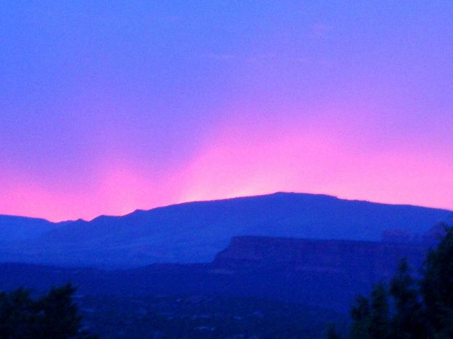 パワースポットとして有名なSedonaに初めて行ったときの写真です。<br /><br />Vortexとして有名なAirportMesaに夕日を見に行ったところ生憎の曇りで見えませんでした。見に来ていた多くの人も帰り、私もそろそろ帰ろうと思ったところ、西の山が燃え出しました。<br /><br />太陽が山の向こうの雲の下に来た為の現象と分かっていても、場所が場所だけに「妖光」と感じずにはいられません。<br /><br />この年は雨が少なく、山火事の危険があるため殆どのVortexへの登山は禁止になっていました。<br /><br />SedonaはMonumentValleyを小さくして砂漠を林にしたような感じのところですが、林の緑と山の赤さのコントラストが絶妙で、MonumentValleyよりも好きなところです。<br /><br />Pheonixからフリーウエーを北上するのが一般的ですが、Flagstaffから南下する方がずっと近いです。
