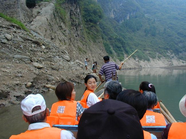 三峡下りの途中で、神農峡を訪ねました。<br />三峡ダムの完工で、現在は水位が上昇したので、この光景は見られません。<br />小船に乗り換えて、最初は人が裸で綱で、舟を引っ張って呉れるのです。<br />正に人海戦術です。<br />神農峡の最深部までに到達する途中の両岸の光景は、素晴しいと感嘆の声が、上がりました。<br />この地峡は、水位が上がった事で、見られないのは、とても残念です。<br />全員がオレンジ色の「救命胴衣」を着けての観光でした。