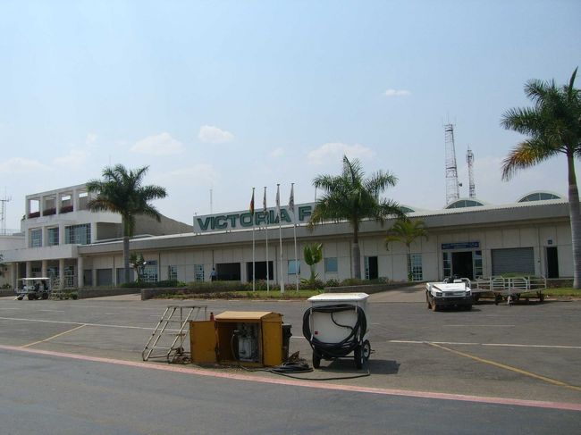 Victoria Falls 空港に到着。平屋建ての簡素な空港である。空港の建物に入ると目の前に入国審査がある。ここで（今のところ）今回の旅行最大のピンチが発生した。入国の際、ビザ料金として30USDが必要であった。旅行の計画のときにその情報は知っていたが、すっかりUSDを準備するのを忘れていた。かろうじて20USD札一枚、2千円程の南アフリカ通貨のRANDしか財布に持っていなかった。2つの通貨を合わせて払えないかとか先にATMに行かせてくれとか交渉したが、まったく取り合ってもらえず。このまま入国審査入り口で2日間も過ごすわけにはいかないので、恥を忍んで列に並んでいるアメリカ人っぽい人にお金を貸してもらうようお願いした。幸いなことに、お願いを始めて3人目の老婦人が10USDを貸してくれたので無事入国することができた。ジンバブエではUSDの入手はできないとの事で、その老婦人には帰国後、郵送で返金することで了解してもらった。本当に助かった・・・。<br /><br />【写真】Victoria Falls 空港