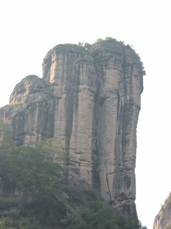 ２００２年の新年をここ福建省武夷山で迎えることになりました。今回の旅行は、３名様同行の４名で行ってきました。正月と言うこともあり予めインターネットでホテルを調べ予約をして行ってきました。しかし、中国は、新正月は休みの日が少ないためホテルも九曲渓もがらがらでした。<br /><br />シンセンから夜便で武夷山空港に到着しホテルの無料送迎マイクロバスに搭乗しホテルまで行きました。マイクロバスに乗っている間、迎えにきたおにーちゃん（ホテルの人間）明日からのガイドどうですかと何度も聞いてきた。私一人ならぶらぶらカメラぶら下げて歩き回りますが、今回は、合計４名ですし、若干２名は殆ど北京語できないので、日本語ガイドをつけることにしました。一日RMB４００程度なので．．．．<br /><br />武夷山第一日<br />この武夷山も世界自然遺産に登録されています。<br />まず、天游峰景区で登山開始。ここでは、一枚岩を登る階段は、約２，０００段。登ること３０分ぐらいで一命脱落しかけている。「先に行ってくれ！」でも。。。。待つこと１０分、回復し無事４名そろって登頂成功。４人で記念撮影をし、疲れたからお茶屋で烏ロン茶を飲んで降りてきました。<br />それから、昼食。川縁の一軒のレストランの外で（オープンテラス）食事。ビールがぶ飲み。<br />今回のメインの九曲渓、筏下り。６人乗りでRMB６００？高い、高いと呟きながらしぶしぶ払い筏に乗船。やはり川の上は、寒い。ビールを飲みすぎたせいで、筏を無理矢理止めさせ岸をダッシュ！木陰に隠れて「ジャー」「フー」すっきり間一髪セーフでした。２時間くらい筏下りを楽しんだ後ホテルに帰りました。疲れたので夕食をホテルで、と思ったが閉まっていた。そこで、外をブラブラしまずは、足マッサージその後は、ホテルで食事をし、年越しそばの変わりに中華面を食べ４人で今年最後の忘年会をしていました。<br /><br />武夷山第二日<br />朝８；００朝食後、天心景区へここは、中国で一番高いお茶が取れるところです。昔から、皇帝に献上したり今では､国家の迎賓用茶として献上しているとの事です。一グラムRMB１６０，０００（約2百50万円）との事です。水簾洞を見学し一度ホテルに戻りました。<br />昼食後、今度は一線天景区へ行きました。体一つしか通れない洞窟の中を歩いてきました。下から上を見上げると空が一直線に見えるので、一線天景区と名付けられたとの事です。<br /><br />第二日目の夜便でシンセンに戻ってきました。今回の旅行は、日本語ガイドを同行させましたので非常にスムーズに動くことが出来て非常に楽でした。今後も、このように出来ればいいのですが。。。。。<br /><br />食事−−−山菜が非常に豊富で、鍋や山菜料理が多いです。<br />お茶−−−天心景区の第二代大紅袍や小紅袍は、美味しいです。（烏ロン茶）<br /><br />