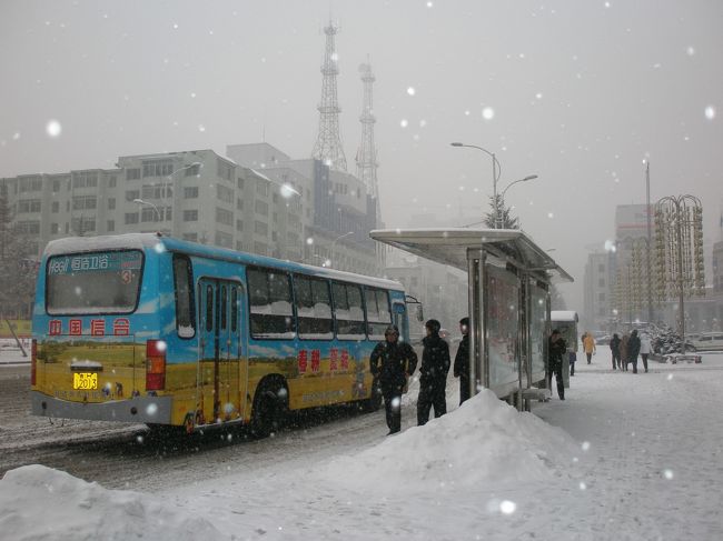 ２００７年１月０６日（土）、早朝から降り始めた雪がかなり積もり始めました。延吉で雪が積もるのは年に３回程度。知り合いが延吉に来ているのですが、この雪でフライトのキャンセルがあるかも・・・<br /><br />写真は延吉市のメインストリート光明街のバス停・報社（延辺日報）前<br />