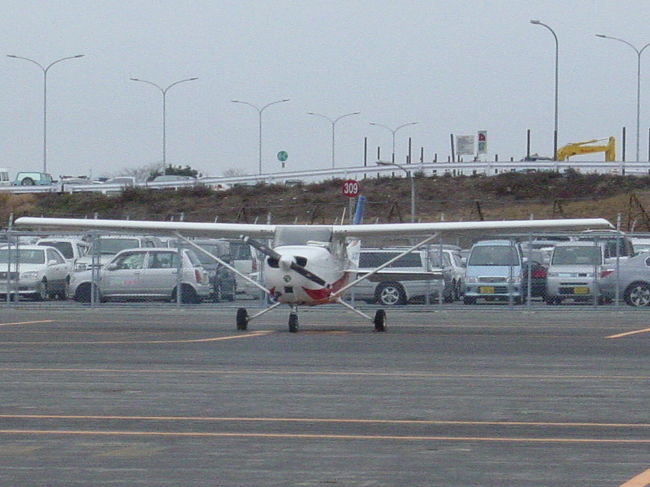 今回は岡山へのフライト。<br />岡山には飛行場が岡山空港と岡南飛行場の２箇所ある（農道空港や滑空場等の場外離着陸場は他にもあります）ので、今日は両方とも訪問してこようと思う。<br />それにしても岡山は久しぶり、岡山空港は約2年前の事業用操縦士の実地試験で行って以来・・・そのときはタッチアンドゴーで八尾に戻ったので地上に居たのは10秒くらい・・・、岡南飛行場は更にさかのぼり約3年ぶりの訪問。<br />今回は珍しく同行者がいます、彼はアメリカで自家用操縦士のライセンスを取り日本の免許に書き換え（自家用ライセンスは書き換え可能）たのだが日本の空はほとんど飛んだことがなく、今日は私がコーチ役で彼が生徒となる。<br /><br />＜1月21日　八尾空港11：30離陸　岡山空港12：45着陸＞<br /><br />今日は空一面の曇天だが、雲と言うよりか濃いヘイズ（もや）のような状態・・・こんな時は前方視程は下がるが、下は意外と見やすい、各地の天候を調べてみても岡山はCAVOK(雲、視程とも問題なし）、大阪、神戸の3500ftに２/８の雲がある程度で風もほとんどないので決行と判断する。<br />11：30八尾空港RWY（滑走路）27を離陸し、1000ftまで上昇しそのまま西進、阪神高速湾岸線に沿って神戸へ向かう。<br />この辺りは以前は明石大橋に向けて海の上を直進していたのだが、神戸空港の開港によって阪神高速湾岸線に沿ったルートでの飛行が推奨されるようになった、西宮浜のマリーナで神戸タワー（管制塔）にコンタクトして管制圏の通過の許可をもらい進むが三宮を過ぎると次第に山が海の近くまでせり出してくる。<br />海上は神戸空港のPCA（特別管制区）になっており許可なしでは入れない、現在神戸からの離陸機が２機あるので許可される可能性も薄い、仕方なく山の上を通過することにする、1000ftでも越えれる山だが六甲おろしの影響も考慮して3000ftまで上昇する。<br />ここからは暫くは播磨平野を姫路に向けて飛行、姫路からは赤穂、日生付近の風光明媚な島々の上を吉井川河口付近にある岡山VORTAC（航法用電波標識）に向かう、今日はもやの中だけど島々と養殖筏？の風景は本当に綺麗である。<br />吉井川に近づくと、前方右側のかなり遠くの小高い丘に空港が薄っすら見えてきた、今日最初の訪問地岡山空港である。<br />岡山タワーにコンタクトすると滑走路は07、西からの進入となる、一旦飛行場の南を西に進み、ぐるっと回りこんで進入する。降下経路に高圧電線があり少し怖い。<br />着陸し空港西端の１３番スポットに駐機し、機外に出る。<br />ちょうど空港上空を西から東に向かう旅客機が見える、数分後その機は再び今度は東から西へまた空港上空を通過し西側からRWY07に着陸した、上海からの中国東方航空だった。行ったり来たりで一見パイロットが道に迷ってうろうろしているようにも見えるけど、これが岡山空港RWY07に西側から着陸する際の計器進入方式の一つ「VOR/DME ILS RWY07アプローチ」なのである、岡山空港に慣れている日本の航空会社のパイロットは天気がいい日は途中を省略して着陸する（もちろんそれも認められている飛行方式です。）<br />空港事務所で着陸料（1050円）を支払い、ターミナルの展望レストランで滑走路を見ながら昼食とする。<br />食事で1時間半ほどレストランに居たけど、先ほどの中国東方航空が折り返しで上海に向けて出て行ったのみで滑走路に動きは全くなかった・・・せっかくの3000ｍ滑走路なのにもったいない。<br /><br />さて、次は岡南飛行場へのフライトである。<br />　<br />セスナで行く岡山・岡南【１】　終わり　【２】に続く<br />　　