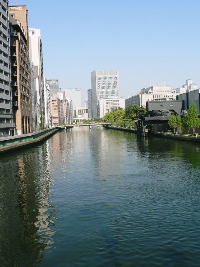 大阪市北区の中心部、大川を堂島川と土佐堀川に分けている、東西約3キロの細長い中洲中之島(なかのしま)は、大坂が天下の台所と言われた江戸時代には、各藩の蔵屋敷が立ち並び、全国各地の物資が集まっていた。明治維新後は蔵屋敷のかわりに、1904年開館の中之島図書館、1918年に完成した中央公会堂、1986年に建て直された市役所、1903年日本銀行大阪支店、大阪大学、病院、企業ビルなどが建設され、大阪のビジネスと文化の中心になっている。<br />(写真は難波橋から見る土佐堀川周辺の光景)<br />