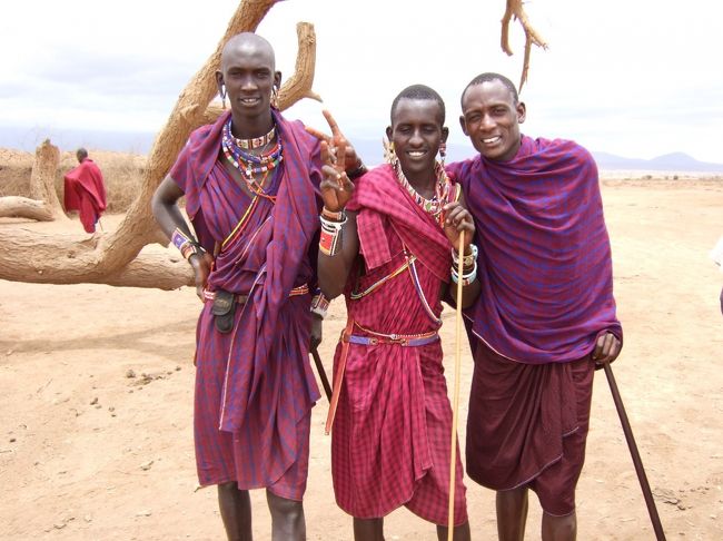ケニアの南西部からタンザニア付近に居住し、家畜とともにアフリカの昔ながらの<br />暮らしぶりを続けるマサイ族の村を訪問しました。<br />村長の息子と名乗る男性に出迎えられ、入村にあたり、まず、20USドルを支払います。<br />赤い布をまとい、カラフルなビーズのアクセサリーで着飾った男女約30名が一列に並び、<br />独特のジャンプによる歓迎を受けました。<br />目の前のウルルンの世界に感激していると、男性陣による石や木の棒を使っての遊びや<br />火起こし棒で火を起こすところを実演しながら、英語での村の生活についての説明が始まります。<br />英語が話せるとは思っていなかったので、ちょっと驚き…。<br />そして、村長の息子さんの家に案内されました。<br />中に入ると薄暗くて、よく見えないけれど、奥さんと男の子がひとり。<br />間取りは土間に部屋が２つ。<br />1つは夫婦の寝室で、1つは子供部屋だそう。<br />土間の真ん中では大きな鍋で牛肉が煮込まれています。<br />ところどころに人間の顔ほどの穴がくり抜いてあるだけなので、家の中はかなり熱がこもった状態です。<br />次に学校（学校と言っても12畳ほどの教室が1つ）に案内されると<br />教室にはマサイの民族衣装を身にまとった先生1名に、<br />かわいい子供たちが約20名。<br />歓迎の意を込めて、Ａ〜Ｚまでを軽快なリズムにのせて、唱えてくれました。<br />すると、どこからか音楽が聞こえてきます…？<br />「次は音楽に合わせて、お歌を歌ってくれるのかしら？でも、なんかこの音って…？まさかね。」<br />と思った次の瞬間、先生が話はじめたら、音楽も止まりました。<br />えっ？え〜〜〜っ！先生が携帯で話してますけど…。<br />マジですか？だって、ここマサイ村ですよね？<br />あなた、マサイ族の方でしょう？<br />火起こし棒で火を起こして、生活しているんですよね？<br />さっき、他の方が見せてくれましたよ。<br />な、なのに携帯って…？ここ圏内なの？電波、届くの？<br />『マサイ族＝携帯電話』の図式がどうしても<br />すぐにのみこめず、呆然と立ち尽くし、自問自答を繰り返す私。<br />こんな事を暴露して、これからケニアを訪れ、マサイ村を訪問しようとしている人、ゴメンなさい。<br />あまりに衝撃的な出来事に私の頭は真っ白に。<br />正直、ちょっと興ざめしてしまった瞬間でもありました。<br />やっぱり、観光用の村だったのね…。<br />