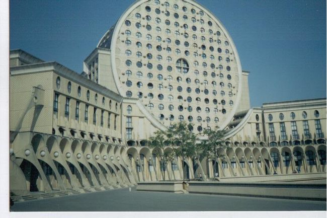 1992年、日本はバブルの終演に近づきつつあったころ、フランスに出張に行く機会があった。<br />日曜日に、パリの郊外に奇妙な建物があるという事なので、出張者のグループで見に行った。<br />パリ中心部からおよそ20分ぐらいの所にあるアパートであるが、ピカソアリーナと呼ばれている。<br /><br />カマンベールチーズを横に２つ並べた奇妙な形。<br />このような奇妙なアパートにすんでいるのは、フランスの旧植民地だったアラブアフリカやブラックアフリカからの移民を中心とした低所得者であるという。<br />パリ市内で清掃などのきつい仕事についたり、失業している人も多いと思われる。<br />どのような背景で、このような奇妙な建物を建築、低所得者を押し込めているのか分からない。
