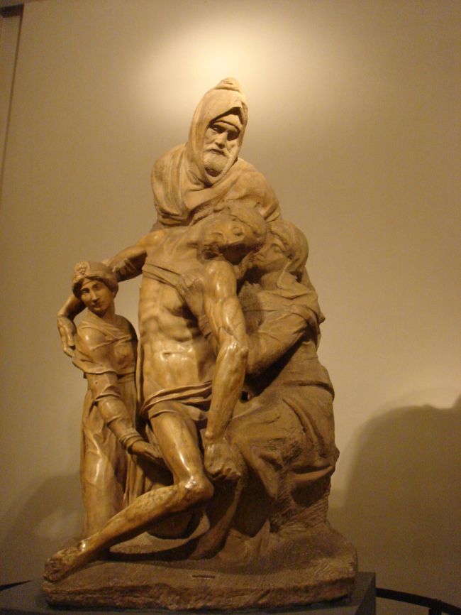 2008　FIRENZE　Duomo付属博物館のPIETA<br /><br />Michelangelo di Lodovico Buonarroti Simoni（1475〜1564）<br />・・・というのが、本名？？みたいですが、舌を噛みそうなので、「ミケランジェロ」<br /><br />★　「ピエタ」とは、「十字架から降ろされたキリストを聖母マリアが抱いて悲嘆にくれている聖母像」、として有名ですが、ミケランジェロは、生涯で４つの「ピエタ」を製作したといわれていますので、全部見たいと、ITALIAへ・・・・・・。<br /><br />【パンディーニのピエタ】（2008.3.11　撮影）　<br />　　　　　　　　　　　　　　　　　　　・・・フィレンツェ<br />　フィレンツェのドゥオモ付属博物館の中２階にありますが、身近で見ることが出来るので、後ろ側に回ると、大理石の原石そのままです。キリストの足や、マグダラのマリアの細部も違和感があり、ミケランジェロ75歳の頃の未完成作品だそうです。・・途中でミケランジェロが自分で壊したそうですが、中央の「頭巾のニコデモ」だけは、見事です。<br />