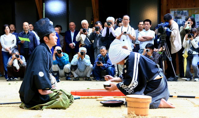 はなちゃんはカメラを通じ知り合いとなつた「ゆーさん」に案内をしていただき、5月5日鏡野町富西谷布施神社・お田植え祭を訪ねました。<br />撮影の後に「布施神社・お田植え祭」ついて尋ねると。平安時代から続けられている豊作を願う神事で、布施神社の当番の皆さんが毎年持ち回りで境内の神事がおこなわれるそうです。<br />　「獅子舞」は神田植えの場所をきよめたのち。子供が牛をまねて牛鍬(うしんが)を引張り新田の田お越しの姿をする「荒起こし」。田植え前の畦付けの様子の「鍬代・くわじろ」。 境内にサカキの葉をちぎってまきジカマキを伝える「田植え」などの神事のあと「布施神社・お田植え祭」で人気がある「殿様と福太郎」の演技は・福太郎が殿さまにご飯を箸(はし)で口元に三度もつていくがいっこうに食べようとしないので、最後に福太郎自身が一気にご飯を食べるという演技の奉納です。殿様にどうにかしてご飯を食べてもらをうとする福太郎の様子を見て境内は笑いがたえませんでした。布施神社の言い伝えとして殿様がお祭りの演技の時に笑うとその年の稲作が凶作となるそうです。また殿様は神事のあと山の神となって山に帰る」と伝えられています。 <br />　 <br />