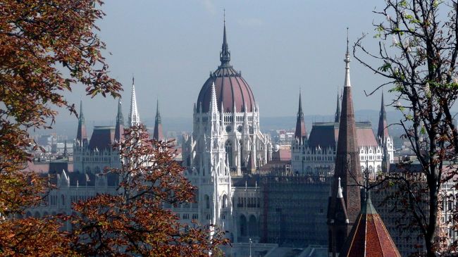 国会議事堂での最初の審議は、ハンガリー建国1000年の年、1896年6月8日に行われた。<br /><br />1885年着工した国会議事堂は完成を見たのが1902年、最初の審議はまだ建設途上の建物内で行われている。<br /><br />ハンガリー最大のこの建物は、長さ268m,最大幅118m,そして高さは建国の年、1896年に因んで96m。<br /><br />この高さは、次に観光する聖イシュトヴァーン大聖堂のドームの屋根の高さと同じにしてある。<br /><br />国会議事堂の正面玄関は、ドナウ川の反対側、コシュート・ラヨシュ広場に面している。<br /><br />ドナウ川に面したドームの屋根を挟むように尖塔が立ち、回廊になっている。<br />かってはその両脇に上院と下院があったらしい。<br /><br />国会議事堂はブダペストの観光中、ドナウ川側の色んな場所で、色んな角度から何度も姿を現す。<br /><br />その美しい勇姿を一纏めにして掲示する事にしました。