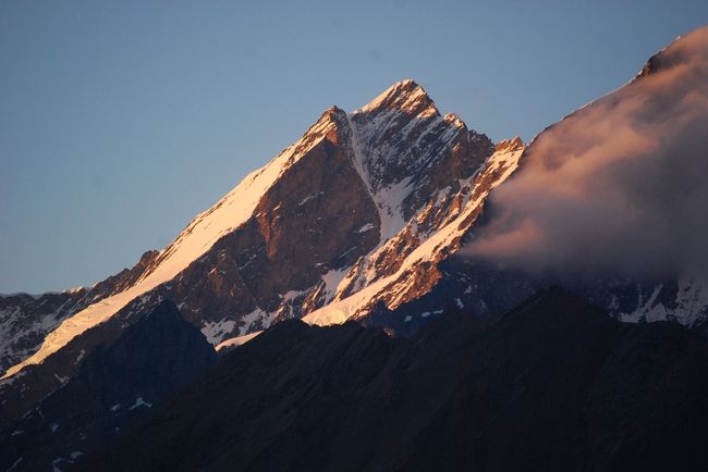 ７月１８，１９日にリッフェルベルグ、ゴルナーグラートより夕焼けやモルゲンロートを眺めることが出来た。<br /><br />ドム峰〔４５４５ｍ〕はミシャベル連峰の主峰であるが、全山がスイスにある山としてはスイスの最高峰である。<br /><br />ドムは南西及び東から見た場合は一連の片麻岩の峻険なピラミッドの連なりの中で最も高い山なのに北西から見ると緑のアルプというようになだらかに見える。<br /><br /><br />＊写真はドム峰の夕焼けをリッフェルベルグから眺めることが出来た