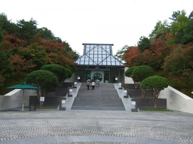 前から行きたかった滋賀県の信楽の山中にある MIHO MUSEUM/ミホ美術館に行って来ました。ＪＲ石山駅からミホミュージアム行きのバスで50分。くねくねと山の中に入って行き目の前がさっと開けて広くなったら到着です。結構遠いです。この美術館は、パリのルーブル美術館のグラン　ピラミッドを建築設計したＩ・Ｍ．ペイ氏の設計でガラスの屋根からの光が明るく開放的でとてもすばらしい建物でした。コンセプトは桃源郷。広いレセプション棟からトンネルを通り橋を渡って美術館棟に行きます。その道500メートル。7人乗りの電気自動車で連れて行ってくれますが、歩いてもとても気持ちのいいものでした。欧米人率高しです。 <br />