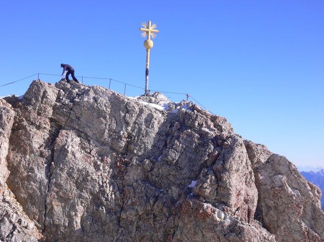 2年程前にZugspitze(ツークシュピッツェ）の山頂からの360℃のパノラマをTV放送で見て以来、ここにも何時か行って見たいと考えていた。<br />ツークシュピッツェは、ドイツ・バイエルン州とオーストリア・チロル州の国境に在り、ドイツ最高峰2,962ｍ(2,964ｍの表示も有るが、）<br /> 山頂の高さは、長い論争の末2,962ｍに決められたとか？<br /> <br />ミュンヘンから列車で１時間30分程のドイツのガルミッシュ・パルテンキルヒェン（Garmisch Partenkihen)という長い名前の町から登山電車とロープウェイで登る事に成ります。<br /> <br />ガルミッシュ・パルテンキルヒェンは、もともと西側ガルミッシュと言う町と東側パルテンキルヒェンと言う町が一緒になって出来た町。<br />今回は、ガルミッシュ・パルテンキルヒェン駅のすぐ後ろにバイエン・ツールピッツェ登山鉄道駅が有りますのでそこから出発して、途中１度乗り換え約１時間程で山頂駅(2,600ｍ）へ、そこから山頂迄ロープウェイで４分でいよいよツークピッツェ山頂に到着です。<br /> <br />山頂までは、色々な行き方が有りました。<br />駅に案内板やパンフレットも有ります。料金も夏と冬場では、10ユーロ位の差額が有りました。<br />帰りは、山頂で見たエメラルドグリーンのアイブ湖（Eibsee)迄、下りて湖を見て、そこから登山鉄道でふもとの町、ガルミッシュ・パルテンキルヒェンの町迄、登山鉄道で下りて行きます。<br />登山鉄道には、車内にもルートマップやビデオの案内、スキー置き場(列車の外）等が設置され、駅、ロープウェイには、日本語の案内が多く見られ、日本からの観光客対策も万全かと？<br /> <br />ツークピッツェの山頂からは360℃パノラマ展望が出来、山頂の展望レストランには方向の案内板も有り、東西南北どちらの方面か分かり易く成っていました。<br /><br />今回、麓の町ガルミッシュ・パルテンキルヒェンで登山電車に乗り込む時も山の方は、雲が掛かり．．．山頂からの眺望は果たして？？<br /> <br /><br /> <br /> <br /> <br /> <br /><br />