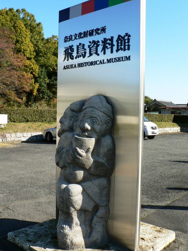 飛鳥資料館は飛鳥時代(６−７世紀)の歴史を展示・解説した博物館で高松塚古墳出土の鏡・玉・飾り金具、飛鳥寺・川原寺・大官大寺・山田寺出土の瓦・セン仏、藤原京全景の復原模型などが展示されている。<br />屋外には、酒船石、猿石などの模造品が並んでいる。飛鳥の歴史や見所を学べるので飛鳥を歩く前に飛鳥資料館で情報収集すると良い。<br />（写真は飛鳥資料館の屋外の光景）<br />