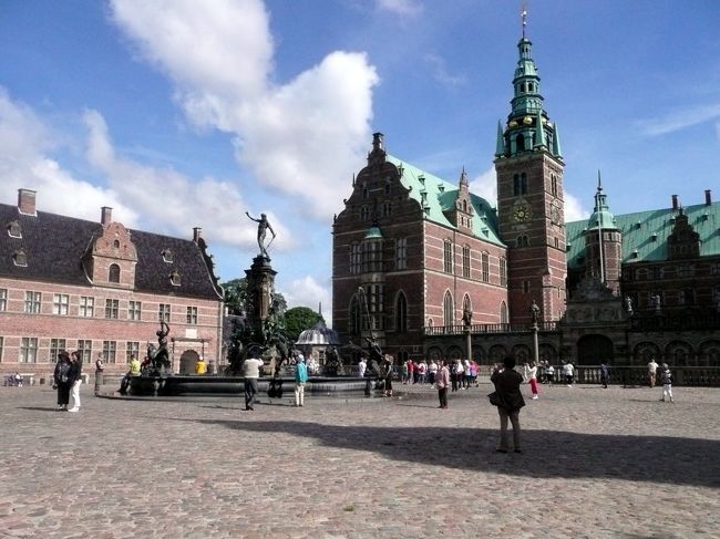 コペンハーゲン2日目。<br /><br />バスは北西に約30kmのコペンハーゲン郊外、フレデリクスボー城の建つヒレレズに向う。<br /><br />フレデリクスボー城は、1600年代にデンマークとノルウェー国王フレデリクス２世がエスロム湖の貴族の館を改築して築いた城を、息子のクリスチャン４世が60年を要して改修し、今の姿になった。<br /><br />その後城は1859年の火災で消失したが、デンマークビールで有名なカールスベア財団のカールスバーグが、王家の住居とはせず、博物館に変更するという条件で復興資金を提供した。<br /><br />今ではコペンハーゲン一綺麗なお城と言われていいる。<br /><br />ヒレレズの街から見たフレデリクスボー城は、街の景観と違和感無く一体となっており、場内の絢爛さとは打って変わってこじんまりとした質素な門。<br /><br />門の先には城の上に建つ搭が見下ろし、通路の両側はれがレンガ造りの長い壁。<br /><br />更に門を潜った所で、フレデリクスボー城が姿を見せるが、城に入るには防衛のためにＳ字型に造られた、しかし眺めの良い橋を渡る。<br /><br />橋を渡り終えると見事なネプチューン噴水のある広場に出る。<br /><br />この噴水のオリジナルはスウェーデンに戦利品としてストックホルムに持ち去られたらしい。<br /><br />ここはまだ二の丸で、本丸は更に壁のさきに建っているのだが、壁越しに堂々とその威容を見せ付けている。<br /><br />航空写真で見るとお城は堀に突き出た小島を利用して点々と建ち、それを橋で繋いでいるようにも見える。<br /><br /><br />到着時はまだ本丸の門が開いておらず、見学に来ている学生たちと暫く待つことに。<br /><br />お陰でオブジェが立ち並ぶ噴水をゆっくり眺める事が出来た。<br /><br />フレデリクスボー城旅行マップ<br />http://www.geocities.jp/tshinyhp/hokuou/hokuoumap/outcopenhagen/frederiks/flamefrederiksbor.html