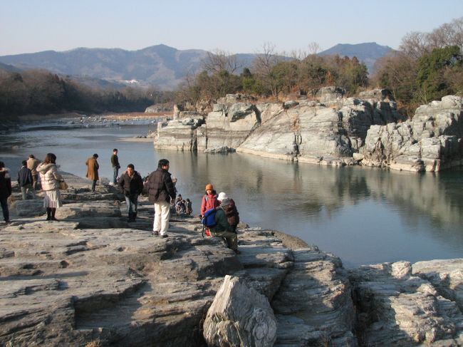 ２月７日、宝登山を下山後、午後２時４０分過ぎに長瀞・岩畳を散策した。<br />シーズン前のためにライン下りはなかったが、冬の景色にもかかわらず訪問客は多かった。<br /><br />岩畳について・・・説明文による<br /><br />長瀞の岩畳は、荒川の流れ約５キロに渡って展開する日本有数の名勝で地質学の宝庫として知られ、約800mにもわたる岩畳は国の名勝・天然記念物に指定されています。<br />岩畳は、大昔の海底につもった砂や泥などでつくられた結晶片岩が長い年月をかけて隆起し、荒川の浸食によってみごとな造形として創造されたものといわれている。<br /><br /><br /><br />＊写真は長瀞・岩畳の風景