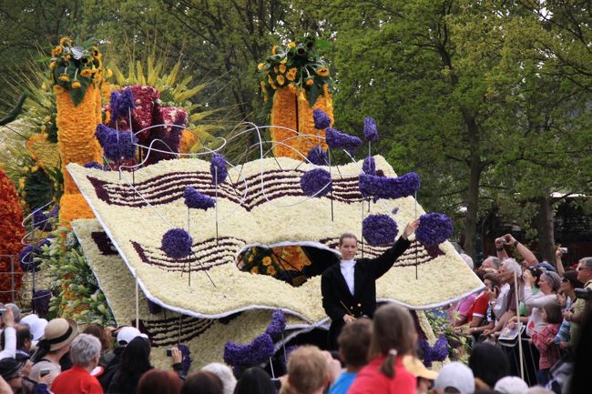 ■キューケンホフの花のパレード<br /><br />☆　チューリップやヒヤシンスなど何万本もの色とりどりの生花で飾られた自動車や大きな山車が、鼓笛隊に先導され練り歩く華やかなパレードを鑑賞しました。<br />思考を凝らした山車が通るたびに、沿道を埋め尽くした観客から驚嘆の声があがっていました。<br /><br />さながら、テーマパークで行われる電飾パレードの電球を生花に置き換えた感じといったところでしょう。<br /><br />■花のパレードはオランダの春を告げるメインイベント。北海沿岸地方40kmを一日かけてパレードします。 コース：北海沿岸の町ノールドワイクNoordwijk（ライデンLeiden駅よりバスで30分程）の灯台下を9時半に出発。15時頃キューケンホフ公園のあるリッセLisseの市庁舎前を通過。ヒレゴムHillegom、ヘームステーデHeemstedeを通り、20時20分頃、ハーレムHaarlem（アムステルダムより各駅停車で20分程）に到着、市内を練り歩いた後、Oude Grachtに展示されます。＜オランダ政府観光局Hp＞<br /><br /><br />_/_/_/　ベルギー・オランダの旅程　_/_/_/<br /><br />□　4/20 　成田発（ヴァージンアトランティック航空901便)　⇒　ロンドン経<br />　　　　　　　由(ブリティッシュミッドランド航空155便)　⇒　ブリュッセル経由<br />　　　　　　　⇒　アントワープ泊<br />□　4/21 　アントワープ市内観光　⇒　ブリュッセル市内観光<br />　　　　　　　⇒　ブリュッセル泊<br />□　4/22 　ブリュッセル　⇒　アンデンヌの森終日観光（モダーヴ城、デュ<br />　　　　　　　ルビュイ、アンヌヴォア城庭園）　⇒　ブリュッセル泊<br />□　4/23 　ブリュッセル　⇒　ゲント市内観光　⇒　ブルージュ市内観光　<br />　　　　　　　⇒　ブルージュ泊<br />□　4/24 　ブルージュ　⇒　キンデルダイク風車群　⇒　デルフト焼工房<br />　　　　　　　見学　⇒　デン・ハーグ市内観光　⇒　アムステルダム泊<br />■　4/25 　アムステルダム　⇒　アムステルダム市内観光　⇒　ライデン　<br />　　　　　　　⇒　リッセ　⇒　キューケンホフ公園見学（花のパレード）<br />　　　　　　　⇒　アムステルダム運河クルーズ　⇒　アムステルダム泊<br />□　4/26 　アムステルダム発（ブリティッシュミッドランド航空102便）　<br />　　　　　　　⇒　ロンドン経由（ヴァージンアトランティック航空900便)　 <br />　　　　　　　⇒　機中泊 <br />□　4/27 　⇒　成田着