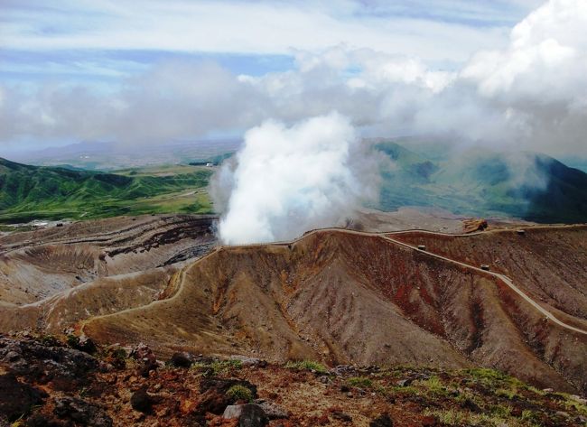 　阿蘇山はカルデラ火山としては世界一の規模を誇る山です。外輪山の中に聳える内輪山の阿蘇五岳と呼ばれる根子岳、高岳、中岳、杵島岳、烏帽子岳からなっており、最高峰は日本百名山にも選ばれている高岳１５９２ｍです。<br />　私達は杵島岳、烏帽子岳に１回、根子岳に２回、中岳、高岳には４回登っていますが、また友を案内して中岳と高岳に登りに出かけました。<br />　仙酔峡から入りましたが、強風でロープウェイは止まっていました。私たちの行った時、ロープウェイの動いていたことがありません。<br />　私達はまず火口展望所まで登り、続けて中岳、高岳と歩き、仙酔尾根を下りました。たいがいは仙酔尾根から高岳に登り中岳へと、私たちと逆コースを辿るのが普通ですが、私は１８０度の展望を楽しみながら下れる仙酔尾根が好きなので、いつも仙酔尾根を下りに使います。<br />　ただここ数年は膝を痛めていたので、「もう仙酔尾は下れないかもしれない!」と思っていました。また仙酔尾根が下れて、とても満足しています。（*^_^*）<br />これも一緒に見てください。<br />☆ミヤマキリシマの花に誘われ久住山〜中岳〜天狗ヶ城に登る☆<br />■ＵＲＬ：http://4travel.jp/traveler/nnkojima/album/10350172/<br />＜癒しの炭酸泉温泉と大吊橋と九重の旅＞＞<br />■ＵＲＬ：http://4travel.jp/traveler/nnkojima/album/10350785/<br /><br />　