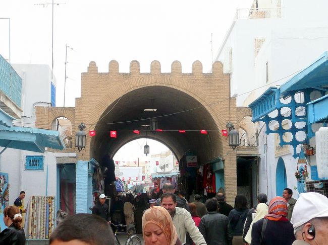 今朝散策したチュニス広場経由で旧市街に入る。<br /><br />今朝ほどではないが、市場にはまだ品物が並び多くの人がいる。<br /><br />ただの泥かと思いきやシャンプーとして使用する、チュニジアの女性には貴重な化粧品だったりする。<br /><br />チュニス門を入り、旧市街のメインストリート11月7日通りを少し進むと、白とチュニジアンブルーの建物の上に前に見えてくるミナレットはガリアーニ霊廟。<br /><br />有名なケロアン絨毯の店や、色鮮やかな陶器の店が目立つ。<br />これから行くミデスでタップリ見せられた砂漠のバラも並んでいる。<br /><br />旧市街の東端はショハダ門。<br /><br />門の入口に可愛い大砲が置かれていた。<br /><br /><br />ケロアン旅行マップ<br />http://www.geocities.jp/tshinyhp/tunisia/tunisiamap/kairouan/framekairouanmap.html<br /><br /><br /><br />