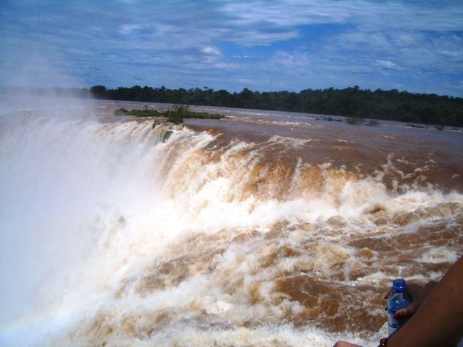 　第２３日目（2004/10/17)<br /><br />　　朝食後、この近くにあるブラジル、アルゼンチン、パラグアイの国境を川で仕切られた三角点を見に行く。<br />　そこに立って川を眺める、二つの川が合流し茶色に濁った川と澄んだ川が合流しまだらとなって流れ下って行く。<br />　<br />今日は車で国境を越えアルゼンチンに入りイグアスの滝をアルゼンチン側から見る。<br />車で途中まで行って、そこからトロッコ電車に乗って滝の近くまで行く。途中蝶々がたくさん飛び交っていてきれいであった。<br />　<br />　電車を降りてから川の上に架かっている橋を渡りながら滝の心臓部に向う。<br />　やがて大きな音と高く舞い上がる水飛沫が見えてくる。アルゼンチン側の滝も落下地点の真上まで行って見た。<br />　悪魔ののど笛といわれている滝が足元からまっさかさまに白い飛沫となり落ち込んでいく。水しぶきがすごくびしょぬれとなる。　ここもじっと立っていると引き込まれてしまいそうである。　安全用の手すりも簡単な手すりしかない、よく事故が起きないものだ。<br /><br />　帰りもトロッコ電車で戻る、あたりを沢山のチョウチョが飛び回り我々を歓迎してくれる。大きな自然の中にいることを実感する。<br />　<br />　<br />　昼食を近くのホテルで滝を見ながら食べる。そして次の中継地点ブエノスアイレスに向かう。<br /><br />　ブエノスアイレスのホテルには夜中の１２時頃入る。<br />