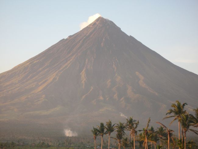 世界でも指折りの完全な形のコニーデ型火山、マヨン・ボルケーノ（２４２１ｍ）を一周した。<br />マニラからフィリピン第二の都市レガスピへ国内線で一時間。雲がかかったマヨン山を左に見ながらレガスピ空港へ着陸。滑走路兼タクシーウェー一本きりの田舎の空港だった。ジェット機は着陸して滑走路の端で回れ右。滑走路の上をタクシングして平屋の空港ビル横に到着。ラゲッジは車で運んできたのを各自で見つけて出口へ、のんびりしたもの。<br />前日電話しておいたのでダンが迎えに来ていた。アルバイ州の国道をマヨン山を右に見ながら１時間。ちょっと大きな田舎町が今日からの宿、雑貨屋の３階に付け足したニッパ椰子の屋根の部屋で数日泊まることとなった。<br />ここを基点に、アルバイ州の北側の海（ラゴノイ湾）と南側のブリアス海峡に面したパンタウへ行った。<br /><br />マヨン山一周はピックアップトラックに総勢１０人で出かけた。フィリピンでは車の定員なんてあって無きが如し。マヨン山の中腹にある教会まで約一時間。標高は５００ｍほどで風が涼しい。<br />山を降り、ティウィ温泉を横に見てソゴットビーチで昼食。南国の景色そのもの。浜は火山灰の小粒の石、白い砂浜ではない。漁船が目の前に着きカツオを下ろし始めた。２ｋｇ一尾１００ペソ、安い。その日の夕方焼き魚で出てきた。僕としてはタタキで食べたかった。<br />マヨン山を右に見ながら、タバコ・シティ、レガスピからカグサワ教会跡へ寄ってみたが、２００７年９月の台風による土石流の中にあってガイドブックのような情緒などなし。<br />ホヨップ・ホヨパン洞窟は国道からかなり南へ行ったところにあった。個人の所有の鍾乳洞でおばちゃんがしっかり番をしていて一人４０ペソ取られた。息子二人がガス灯を手にガイドしてくれる。入り口から少しだけ電気が引いてあるが、奥は真っ暗。一周約一時間、我々だけなのでゆっくり回れた。鍾乳石、石筍、ドーム、洞窟内の小さな川など鍾乳洞の一式がすべてそろっている。途中で一度外へ出るとマヨン山が遠くに見える。洞窟は上下二段になっているようだ。ここへのアクセスは個人では難しいと思う。<br /><br />翌日ブリアス水道に面したパンタウへ行く。アルバイ地方への２度目の訪問でやっと行けた。山越えの道を一時間。途中２００ｍほどの高さから見下ろすブリアス水道の眺めが良い。ここへは誰も日本人が来たことがないとの事。パンタウはひなびた漁師村。交通はリガオかポランギからジプニーにゆられることになる。浜辺は砂地だが白く無く遠浅でもない。唱和３０年代の日本の漁村のような雰囲気の村。違っているのは漁船の形と（半分は手漕ぎでエンジンが無い）浜辺を歩き回るアヒルたち。時はゆっくり過ぎてゆく。ここの小学校はマングローブの浜を切り開いた中にあり、大潮のときは校庭まで海水が来るので校舎は一段高くしてある。夜は蛍が舞う。のんびりした人たちと自然しかない。<br /><br />マニラまでは冷房の効きすぎの夜行バスで１０時間の旅であった。<br /><br />