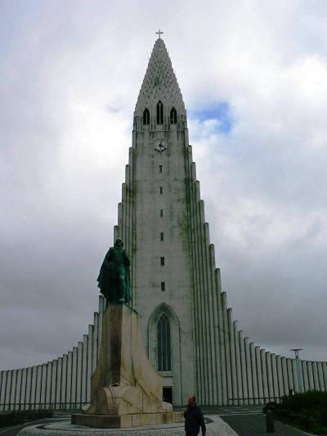 レイキャビクは８７０年頃ヴァイキングが定住地としたことが始まりとされている。<br />アイスランドは長年デンマーク王国に統治されていたが、１９１８年にデンマーク王権下でアイスランド王国としての独立している。だが完全な独立は第二次世界大戦後という比較的新しい国で王政を廃止し大統領政を選択している。<br />レイキャビクを歩くとまずランドマークであるロケットのような形のハットルグリムス教会が丘の頂上にそびえ立っているのが見える。高さは約７５ｍのアイスランドで最も高い建造物で完成は１９８６年だが計画から完成まで４１年も要したそうだ。教会のエレベータ（３５０クローナ・６００円）で展望台に登るとカラフルなレイキャビクの街が一望できる。展望台から見えるチョルトニン湖の湖畔には１８８１年に建設され、世界最古の民主議会場と言われる国会議事堂や首相官邸、市庁舎などの政府機関が集中しているがどれも小規模な建物だった。チョルトニン湖の湖畔は市民の憩いの場となっており、子供連れの家族が楽しんでいた。<br />（写真はレイキャビクのロケットのようなハットルグリムス教会）<br />