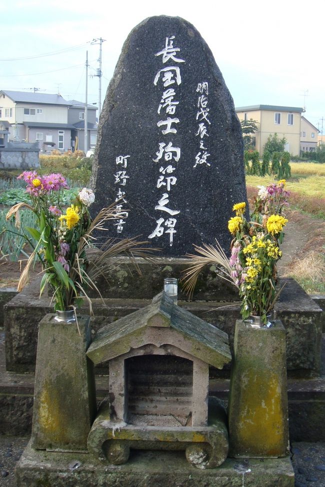 時は慶応４年、西暦１８６８年。歴史は江戸時代から明治元年への政変の真っ只中。戊辰戦争の悲しいお話です。会津城下に援軍にきた長岡藩大隊長の山本帯刀（たてわき）以下43名が濃霧のため同盟軍から孤立、銃撃され生き残った三十数名が生け捕りにされた。薩摩藩淵辺直右衛門を含む３人の軍監は降伏を迫ったが、「降伏に来たのではなく戦いに来た」と降伏を拒否した。山本帯刀をはじめ長岡藩士の＊斬首が決まり、９月８日藩主そして長岡の方向に別れを告げ、粛々と異郷の地に散っていった。鶴ヶ城開城の１４日前の出来事でした。この方々の記念碑「殉節越後長岡藩士の碑」をお参りしてきました。山本家は跡取りが亡くなりましたが高野五十六が家督を相続、山本五十六（やまもといそろく）と改名しました。有名な大日本帝国海軍、連合艦隊司令長官です。「飯寺に散った若き大隊長山本帯刀」「慈眼寺のホームページ”管理人のひとりごと：http://www7a.biglobe.ne.jp/~jigenji/yamamoto.htm」より参考にさせていただきました。後編は「刀とお金を預かった西軍、宇都宮藩士」をアップしました。