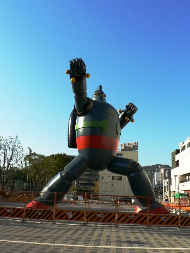 新長田駅前の若松公園には阪神大震災復興のシンボルとして制作された全長１８m、重量約５０トンの「鉄人２８号」実物大モニュメントが設置されている。 <br />鉄人２８号モニュメントは、原作者の漫画家・横山光輝（よこやま みつてる１９３４−２００４年）氏が神戸市出身であることから、地元商店主らでつくるＮＰＯ法人「ＫＯＢＥ鉄人プロジェクト」が震災復興のシンボルとして個人、企業からの寄付・協賛金や神戸市からの補助金などを集め、総工費１億３,５００万円で建設したもので将来的には「横山光輝記念館」の建設も目指しているそうだ。<br />１１月６日には鉄人２８号モニュメントの周囲にまだ工事中の柵が置いてあったが商店街周辺や地下鉄新長田駅には鉄人プロジェクトのポスターが貼ってあり、商店街では鉄人２８号グッズを販売し街は活気づいていた。<br />（写真は鉄人２８号のモニュメント）<br />