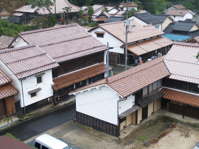 　松江城下にあった島根県立博物館が古代出雲歴史博物館として出雲大社脇に新装なった。行ってみたいと思っていたら石見銀山展をやるというので見に行くことにした。世界遺産登録は見送りかと思われていた石見銀山が急遽7月に世界遺産に登録されて間もない9月に石見銀山展をやるというのであるから、何とタイミングの良いことか。さぞ準備が大変だっただろうと思った。しかも、博物館から銀山行きのバスも出る。まさに渡りに船とはこのことだ。初日に博物館を見学し、翌日のバス予約を入れ、翌朝一番電車で出かけることにした。松江しんじ湖温泉駅前のホテル一畑に2泊お世話になるのだが、バス時刻には一畑電鉄の一番電車でないと間に合わない。ホテルで「明日朝の朝食はどうされますか？」と聞かれ、「博物館からのバスで石見銀山に行くので、7時からの朝食を食べていたら間に合わない。」と答えたら、「サンドウィッチをお作りしておきますから、お持ち下さい。」と言われた。翌朝、ホテルのサンドウィッチを持って出かけ、駅で半分食べて、残りをバックにしまった。これが後々助かった。<br />　石見銀山龍源寺間歩へはマイクロバスが往復していた。天気がはかばかしくなく、観光客が前日の3割程度ということだがバスは満杯で途中からは乗車はできなかったくらいだ。道は狭く、車のすれ違いが中々できない。バスが路肩に寄ると乗客からワーという声が上がる。すれすれまで寄った路肩の下は崖なのだ。落ちたら一溜りもない。町の人はバスが来ると脇道に避け、バックして元の道に戻る。こんなに狭い道で足りていたところに世界遺産に登録されたからと言って観光客が大挙押しかける訳だから、地元の人の生活も一変する。世界遺産に登録されると観光客が1桁増えると言われるが、ここ石見銀山では登録初年度の観光客は前年の3倍に止まった。この道路事情がネックとなり、そうさせたのであろう。また、昼時はどのお店も満杯であった。元々街には飲食店はそれほど多くはないのだ。ここで朝のサンドウィッチの出番だ。大森の町に帰る道すがら、屋根の付いた東屋のベンチで雨宿りしながら残りのサンドウィッチを平らげた。途中、鐘楼のあるお寺（西本寺）に寄り、お寺の人と話していると、子供が、「お父さん、この人と知り合いなの？」と尋ねる。これまでは観光客も少なく、初めての人と話すことはほとんど無かったであろうが、これからはそうはいかなくなる。世界遺産に登録されて観光客が溢れ出すからだ。幼い子供でも理解できるようになるまでにはそう時間はかからないであろう。<br />　大森の町は赤い石州瓦が綺麗な町であった。銀山飴をお土産に買った。客の少ない雨の日でも昼過ぎには飴は2袋か3袋しか残ってはいない。もうそろそろ開店休業になる。<br />　石見銀山の佇まいよりも大森の町に暮す人たちのことが心に引っかかる旅でした。