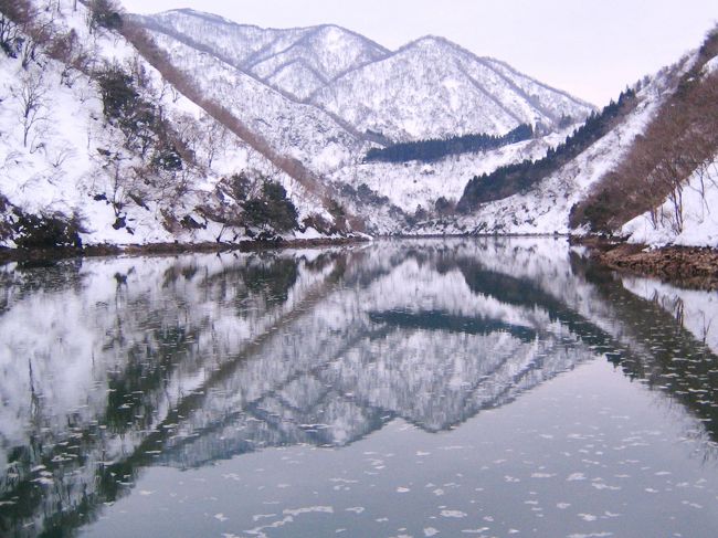 世界的にも有数の豪雪地帯のツアー<br />コースは、井波・瑞泉寺〜大牧温泉〜白川郷〜飛騨古川の町並み散策♪<br />一泊二日なのに高めのツアー料金・・・<br /><br />庄川に沿っての冬景色は、身も心も凍えそうなシーンが続く。<br />何故だか庄川峡に行きたくて、色々企んだけど流れつづけ・・・<br />「かんぽの宿」が閉館されるのを聞き、慌てて２００４年２月に訪問。まさに閉館直前！<br />近年、高速道路の開通で良くなったが、秘境と言われるだけあってアクセスが非常に悪かったエリアだ。 <br /> <br />一級河川の庄川は岐阜県鷲ヶ岳（1,672m）と烏帽子岳の間の谷が水源といわれている。<br />一色川と合流した庄川は、高山市荘川町牧戸で御手洗川と合流し、御母衣湖から白川村を経て北上し富山県に入る。<br />庄川峡を経て、砺波市庄川町で平野部に出て北流し、射水市新湊で富山湾に注ぐ。<br /><br />切り立つ山々の麓を流れる川は男性的。<br />悲しいドラマを凍らして隠しているようなシチュエーション！ <br />そんな感傷的になれる風景が忘れられなくて再訪。<br />今回のツアーは１人参加可（同性の相部屋）<br />そう、独りでも行って見たい雪景色がそこにあるのだ。<br /><br />「暖かい」と言っても大寒、そこそこ寒い。<br />冷たいデッキで凍える手を温め、思い出を弄りながらシャッターを押した。<br />表紙は、庄川に映る五箇山。<br /><br /> 