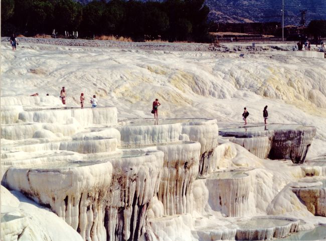 PAMUKKALE（パムッカレ遺跡）と言えば、その丘の上の遺跡を押しのけて必ず観光パンフレットに登場する「石灰棚」。<br /><br />例え、頂上にローマ時代の貴重な遺跡があろうと、遺跡管理人と名乗る怪しげな男に遺跡入場料をしつこく請求されようと、この丘の中腹に広がる白い棚田に足を止めない観光客はいない。<br /><br />消し忘れたロウソクを朝に発見した時もこんな感じにテーブルがデコレーションされていた気がする。<br /><br />しかも、この石灰棚の中身は温泉だった！<br />世界的な観光地でヨーロピアンのおじちゃん、おばちゃんが水着で「ババンバ・バン・バン・バン」とくつろいでいらっしゃった。