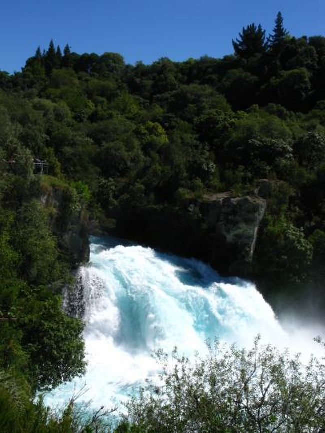 フカ滝Huka Falls<br />ニュージーランド最長のワイカト川は、タウポ湖の北側から幅100メートルの谷間をゆっくりと流れ出しますが、フカ滝のすぐ手前の地点で、硬い岩からなる狭い谷間へと流れ込みます。このため、消火用ホース先端の細いノズルから水が勢い良く噴出するのと同様に、そこまで静かに流れていた水は急激にその速度を増して狭い谷間を急流となって走り、さらに、11メートル下の滝壺へと轟々と流れ落ちるのです。フカ滝のすぐ真上に設けられた展望用の橋からは、毎秒22万リットルもの水が落ちる迫力あるフカ滝の姿を間近に眺めることができます。フカ滝を囲むように設置された展望台からは印象的な写真を撮影することができるでしょう。 <br />（http://www.newzealand.com/travel/ja/sights-activities/scenic-highlights/scenic-views/scenic-highlight-details.cfm/businessid/63876.html　より引用）<br /><br />フカ滝は、ニュージーランドで最も訪れる人が多い景勝地のひとつです。轟音とどろくフカ滝では、1秒間に22万リットル以上もの水が崖を勢いよく流れ落ち、白い水しぶきを上げています。絶好の写真ポイントとなっており、タウポでは見逃せない観光ハイライトです。ワイラケイ・パークの中にあるフカ滝はタウポ湖から車で5分の距離にあります。またワイカト川の川岸を30分ほど歩けば、歩道沿いにある展望台からフカ滝を眺めることができます。<br />（http://www.newzealand.com/travel/ja/destinations/regions/taupo/taupo-scenic-highlights.cfm　より引用）<br /><br />6日目 （２月28日・日）<br />8:50クイーンズタウンより空路、北島・ロトルアへ。（クライストチャーチ経由。クライストチャーチでは20〜30分の降機）（約3時間05分）<br />11:55　ロトルア到着。レストランで昼食後、タウポへ。（約76km、約1時間15分）ニュージーランド最大の湖タウポ湖（下車・約20分）・毎秒約30万リットルの水が流れ込むフカ滝（下車。約20分）を観光。<br />その後、温泉とマオリ族の街・ロトルアに戻り、市内観光へ（ロトルア湖（車窓）、間欠泉で有名なテ・プイア（下車））（約1時間半）<br />18:00　ホテルへ。夕食はマオリショーを見学しながらハンギディナー。<br />【宿泊：ロトルア・スディマホテル レイクロトルア泊】<br /><br />ニュージーランドの最新情報については・・<br />http://www.newzealand.com/travel/Japan/<br />http://www.newzealand.com/travel/ja/about-nz/about-nz-home.cfm<br />http://www.newzealand.com/travel/ja/sights-activities/scenic-highlights/scenic-highlights-home.cfm<br /><br />ニュージーランドのビデオについては・・<br />http://www.newzealand.com/travel/ja/multimedia/video/video_list.cfm/sorttype/mostpopular/sortorder/desc/itemtype/MP.html