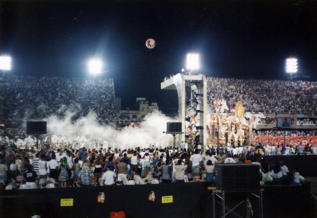 １９９７年２月２２日、とうとうやっと世界三大祭りの一つ、「リオのカーニバル会場」にやって来た！<br /><br />そう「会場」、正確にはカーニバル・パレードの為だけに作られた「サンバ・スタジアム」だ。<br />リオのカーニバルと言えば、街中で人々が踊り狂っているイメージしかなかったが、実際はブラジル各州から選抜されたサンバ・チームの決勝大会の事だった。<br />つまり簡単に言うと、日本の夏の高校野球と同じで、ここリオの会場は甲子園に当たるわけ。<br /><br />当然スタジアムに入るには、席のチケットを買わなければならない。<br />一番安い席でUS$20！<br />そして、カーニバル開始が夜８時、終了が朝の７時！<br /><br />そう、夜を徹してのカーニバルが今始まろうとしている。