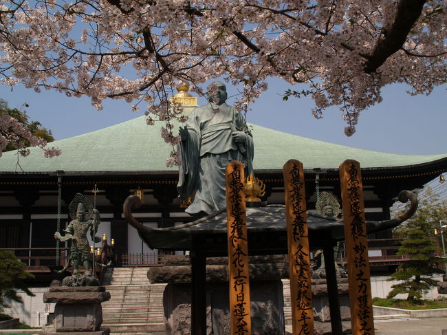名越踏切を渡った鎌倉市材木座にある長勝寺は日蓮宗の寺院で、石井山長勝寺という。創建は弘長3年(1263年)、開山は日蓮上人、開基は石井長勝である。<br /> 境内には日蓮大聖人辻説法像と囲むように四天王が建っている。この日蓮上人像は、関東大震災直後の大正12年(1923年)10月に洗足池畔に建立されたものが、昭和41年(1966年)に長勝寺に移されたもので、高村光雲作である。洗足池は日蓮上人ゆかりの地であり、身延山久遠寺から常陸へ湯治に向かう途中に、池のほとりで休息し足を洗ったという言い伝えが生まれ、「洗足」となった。また、日蓮上人が袈裟をかけたと言われる「袈裟掛けの松」(3代目)も残っている。<br /> 寺では檀家以外にはトイレを貸してくれない。そのためではないだろうが、桜の頃でも境内にはさほど多くの人はいない。本堂や日蓮上人像と四天王が建つ境内は何か派手さがある寺ではあるが、何時行っても人は少なく、落ち着いた雰囲気の寺である。<br />(表紙写真は長勝寺本堂(帝釈堂)と日蓮大聖人辻説法像)