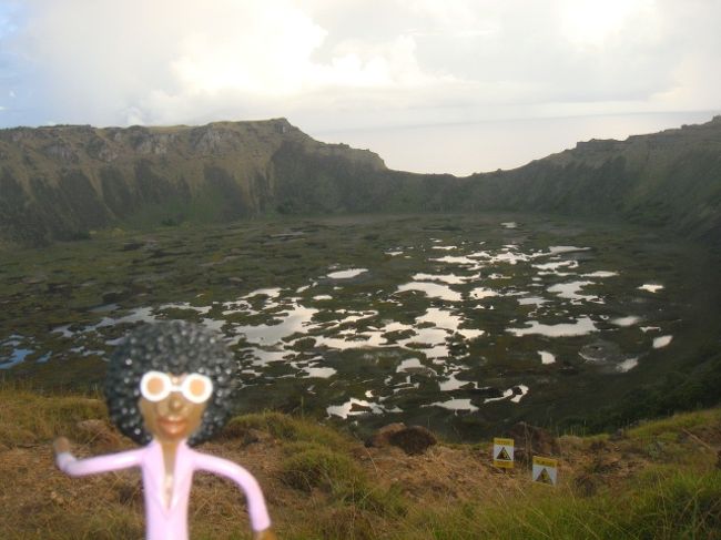④イースター島 ラノ・カウ<br /><br />02/23/09 <br /><br />「RANO KAU ラノ・カウ」に向かう前に1日中トイレを我慢していたなみおは、通り道のミヒノアに寄って貰うことに。部屋に立ち寄ると、ルームメイトのサトコさん&マユミさんがいたから一緒に「ラノ・カウ」に行かないか誘ってみた。車もピッタリの人数だと思ったら朝会ったミヒノアの掃除のおっちゃんも行きたいと言い、結局6人で出発することに。<br /><br />「ラノ・カウ」は、大きなクレーターがあり、所々トトラ(葺)で覆われ、その隙間に見える火山湖に雲が反射して見えるのが美しかった。そのまま「ORONGO オロンゴ」へ行ってみるも、閉まっていて中に入ることが出来なかった。<br /><br />なみお達の隣では、リッチなツアーに申し込んだオジ様&オバ様達の為にキャンピングチェアーが並べられ、そこでチーズやらサラミをつまみにワインが振る舞われていた。みんなここで夕日を眺めながらリッチなひとときを迎えるらしい。なみお達といえば指をくわえながら羨ましく眺めるばかりだった(苦笑)<br /><br />ミヒノア前の海で眺める夕日が最高だった。荒波が岩にぶち当たり、砕け散って行くのを幾度も繰り返し、オレンジの夕日が水平線に沈んでいく。本当にキレイだった。<br /><br />熱で意識が朦朧として、かなりしんどい1日だったけど、盛り沢山でモアイといい夕日といい最高だった。