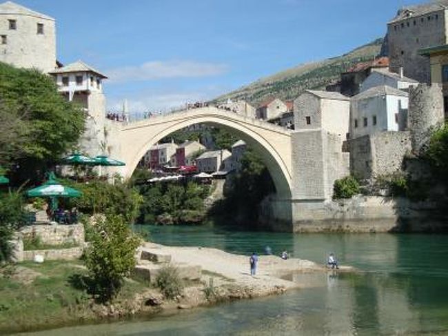 １６世紀のオスマントルコ帝国時代に美しい石造りの橋が架けられました。<br />１９９１年より旧ユーゴースラビアの崩壊の発端となった宗教紛争で１９９３年に美しい古橋は、<br />破壊されてしまいました。<br />１９９５年の戦争終結後も橋は破壊されたままでしたが、平和の象徴として２００４年に石橋が復元されました。<br />もともとオスマン帝国の一部であったため街にはモスクが多く見られました。<br /><br />モスタル旧市街の古橋地区　　　２００５年世界文化遺産に登録<br />