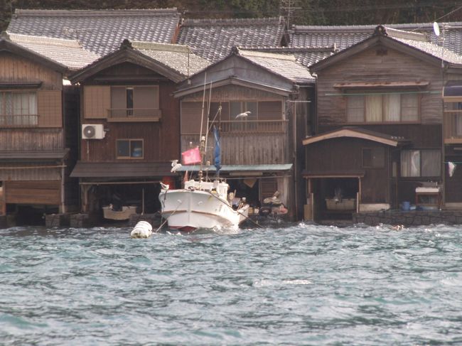 　京都府与謝郡伊根町は伊根湾の海に面して230軒あまりの「舟屋」が建ち並んでおり、重要伝統的建造物群保存地区に選定されている。伊根の舟屋を舞台にした、NHK連続テレビ小説「ええにょぼ」が放映されたのは平成5年（1993年）のことである。もう17年も前のことで、主演女優であった戸田菜穂も今年は年女である。<br />　伊根の町は道路から散策したのでは単にどこにでもあるような漁村風景であるが、海から眺めると一変していた。海に向かって舟屋が建ち並んでおり、舟屋の前に船が停泊し、舟屋の中にも船がある。舟屋は船のガレージなのだ。<br />　また、丹後半島の北端に位置する伊根湾には小島が浮かび、小さな祠が建っている。この伊根湾があるために、冬の日本海の荒波からも、時化や嵐、台風の時でも伊根の舟屋を守ってきたのであろう。外海は荒れていたが伊根湾は風があったが、さざ波が立つ程度であった。沖合には生簀が浮かび、空をカモメが飛び交っていた。この湾内では遊覧船からカモメに餌をやることはない。おそらくは、伊根の舟屋の漁師とカモメとの関係がそうした観光の1アイテムを必要とはしないのであろう。<br />（表紙写真は伊根の舟屋）