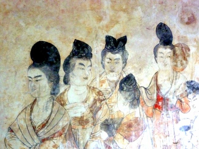 広大な「乾陵」には陪塚が17もあり、「永泰公主墓 」もその一つ。<br />「永泰公主墓 」は乾陵博物館と同じ敷内に隣接している。<br /><br />墓の主は永泰公主、本名李仙、皇帝高宗李治と皇后則天武后の孫、息子中宗の第七皇女である。<br /><br />公主の死因は棺には難産と書かれているが、実際は皇帝になった則天武后が、武后の若いそばめの兄弟に一切を任せる政務のやり方を、公主が夫共々批判していたため、武后の怒りに触れて二人共殴り殺されたと云うことらしい。<br /><br />公主はまだ17才の若い妻女であったし、公主の夫は武后の親戚筋の者であった。<br /><br />最初公主は洛陽に葬られていたが、則天武后の死後、父中宗は洛陽にあった娘の墓を乾陵の近くのこの地に移し葬った。<br /><br />墓は土を盛って造られ、玄室迄87.5mのトンネル状のスロープが有り、トンネルの壁には白虎や青龍、高松塚古墳の壁画のモデルと云われる唐の女官や官吏達が描かれており、女官達の艶っぽい美しさに目を奪われる。<br />(ガイドさんに頼んで、NOフラッシュで壁画を撮る許可を得た。)<br /><br /><br />「乾陵博物館」には「永泰公主墓 」を中心に、乾陵の陪塚から発掘された出土品が時代毎に分類されて展示されている。<br />西域の人の姿の埴輪が多く見られ、この時代シルクロードとの交流の深さが感じられた。<br /><br />「唐高宗与則天武后皇帝合葬之墓」で時間を喰った為、乾陵博物館は流し気味の見学。<br />