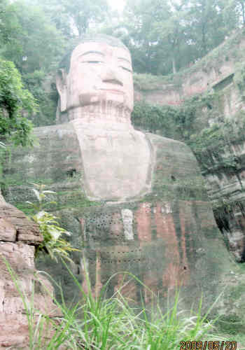 楽山大仏は岷江と大渡河、青衣江の合流点の凌雲山に建って、歴史が約1300年になります。昔はこのあたりでは、よく増水してあふれたり、船が沈没したり、水難事故がよくありました。それで、唐代の713年に、海通という名僧が川を治め、また事故で死した人の霊を慰めるために、この大仏を造り始めました。完成したのは九十年代後の公元<br />803年ので、90年間が彫り続きました。何世代もの人が彫り続けてできたものとしては、よく均整がとれていたのです。こんなに大きな工事を建つためには当時の条件ではかなり簡単ではありませんでした。言い伝えでは、海通和尚はこの大工事のために、20年間もたく鉢をして回り、たいへんな苦労をして、たくさんのお金をためました。着工してからも、度々地元の官吏から恐喝されたり、ゆすられたりしましたが、そのつどきっぱり断ったのです。最後には海通和尚は自分の片目をえぐり取って見せて、それでもお金は悪い官吏に一銭もやりませんでした。ですから、地元の人たちは海通和尚を記念するために、彼がかつて修行した場所に祠を建てた。<br /><br />